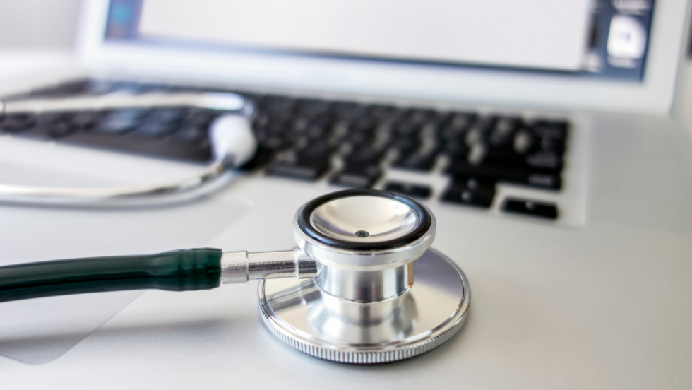 Stethoscope on top of an open laptop